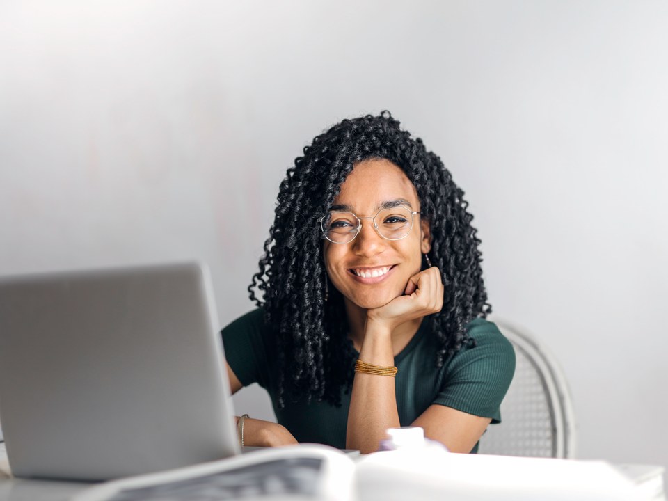 Illustrative photo of a smiling professional working at a laptop.